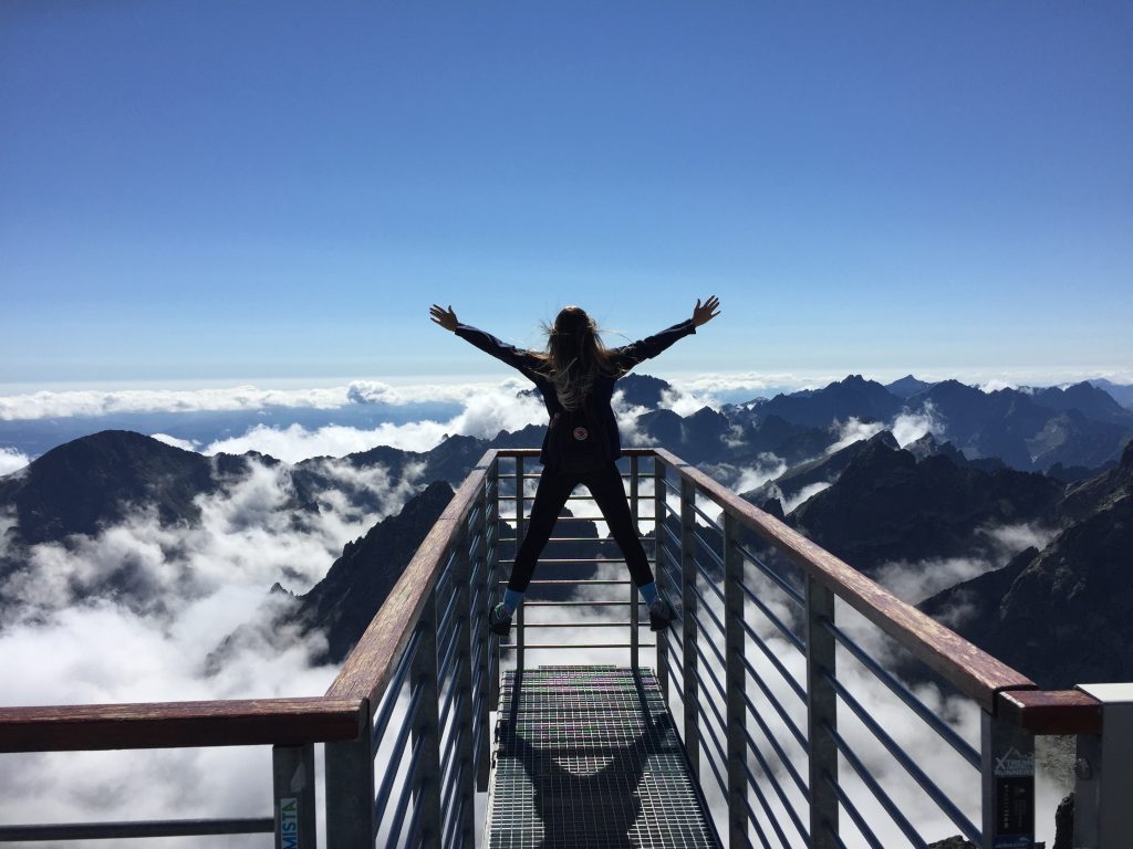 Person on top of the world (above mountains)